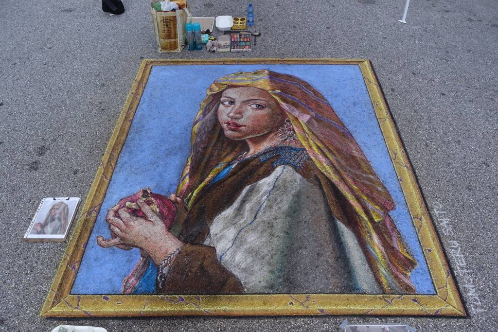 A chalk drawing of a woman on the sidewalk.