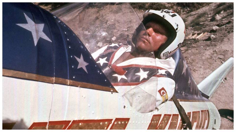 A man sitting in a plane with an american flag on it.