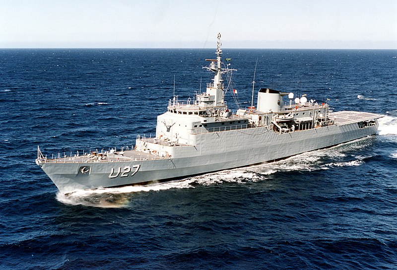 A large navy ship traveling in the ocean.