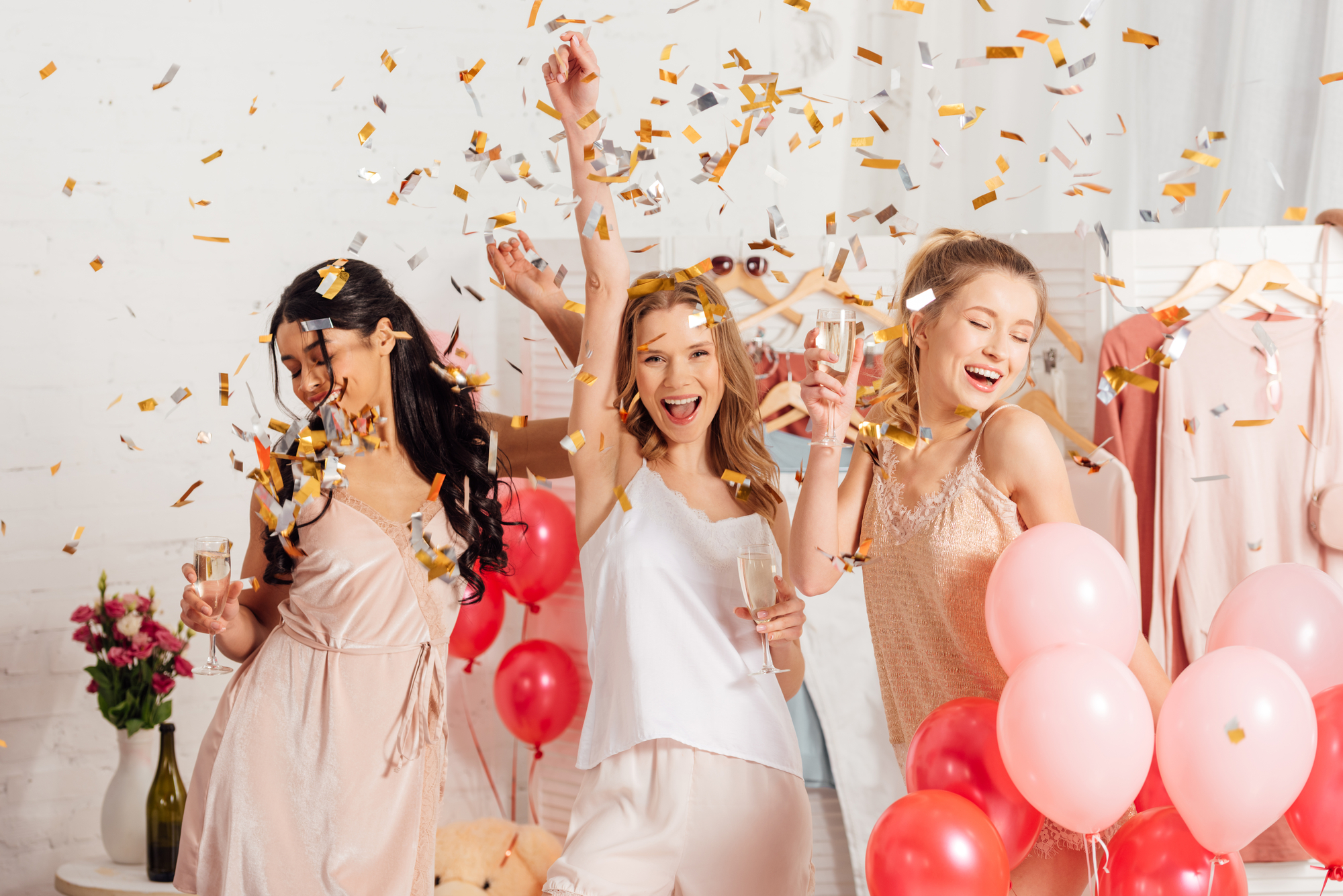 A group of women celebrating a bachelorette party with special balloons and confetti.