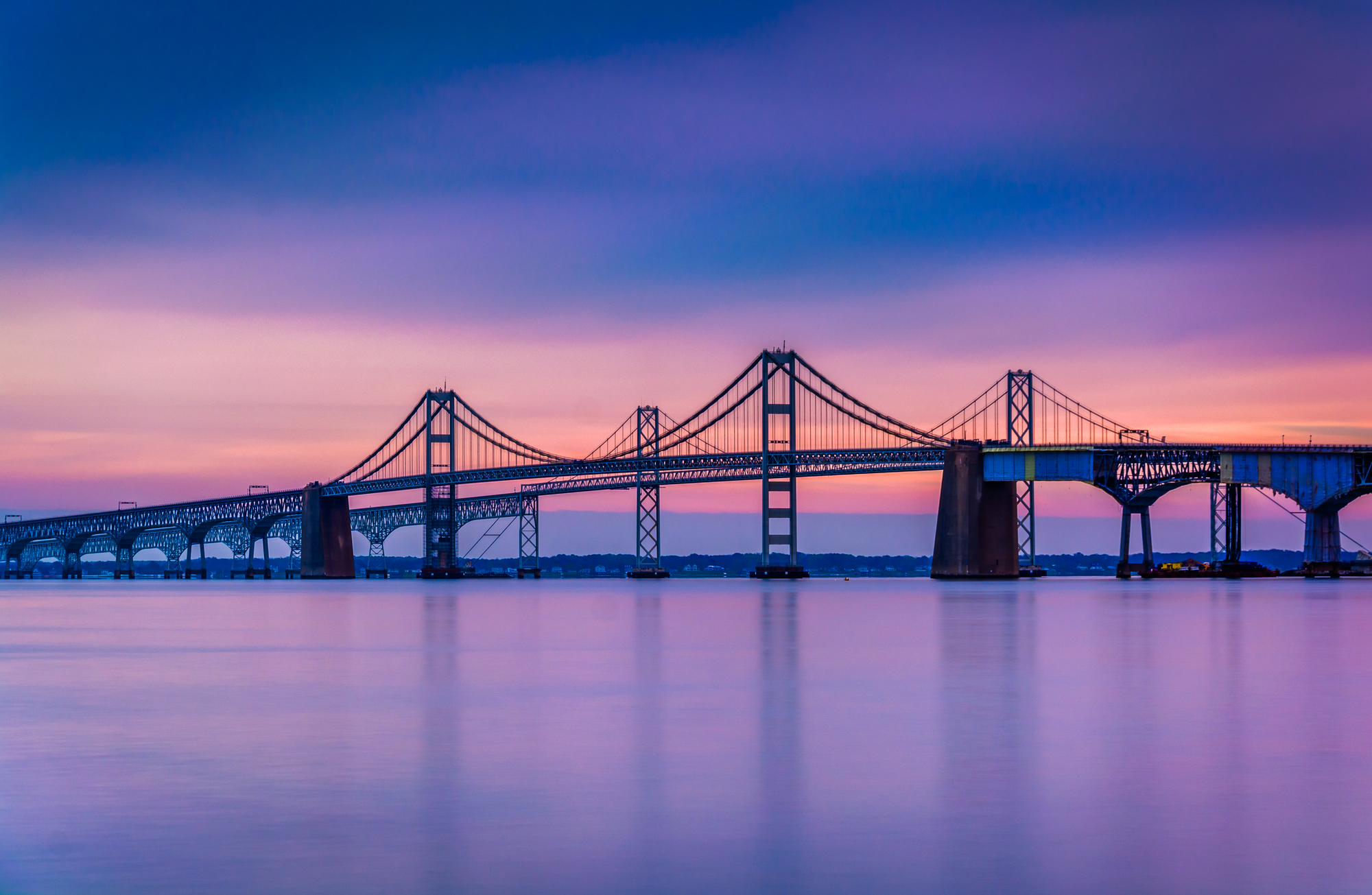 A scenic bridge over a body of water during a beautiful sunset in Maryland.