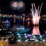 Fireworks light up the sky over a city at night.