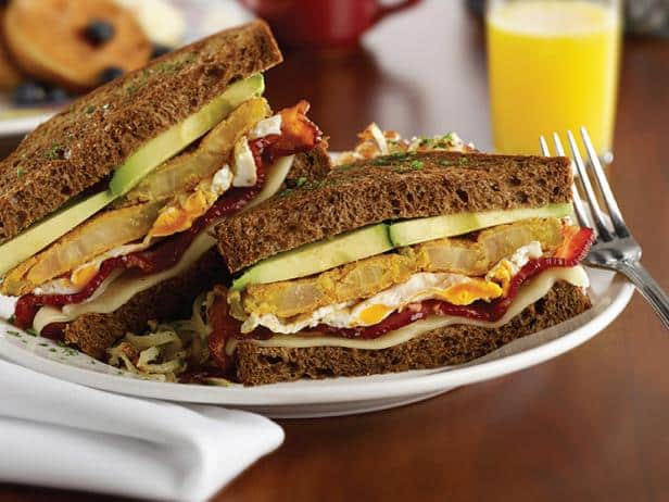 Two sandwiches on a plate next to a cup of orange juice at Miss Shirley's Cafe.