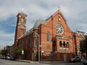 A festive red brick building with a clock tower in Little Italy, Baltimore.